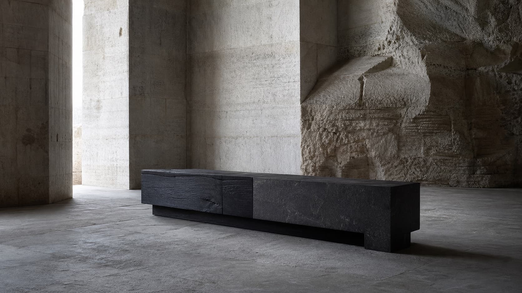 A dark timber bench presented in a quiet limestone interior.