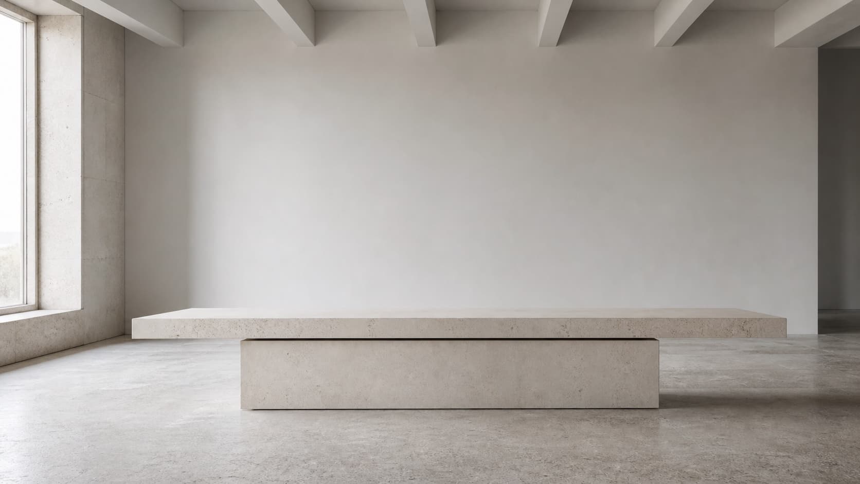 A pale stone table presented in a quiet architectural room.
